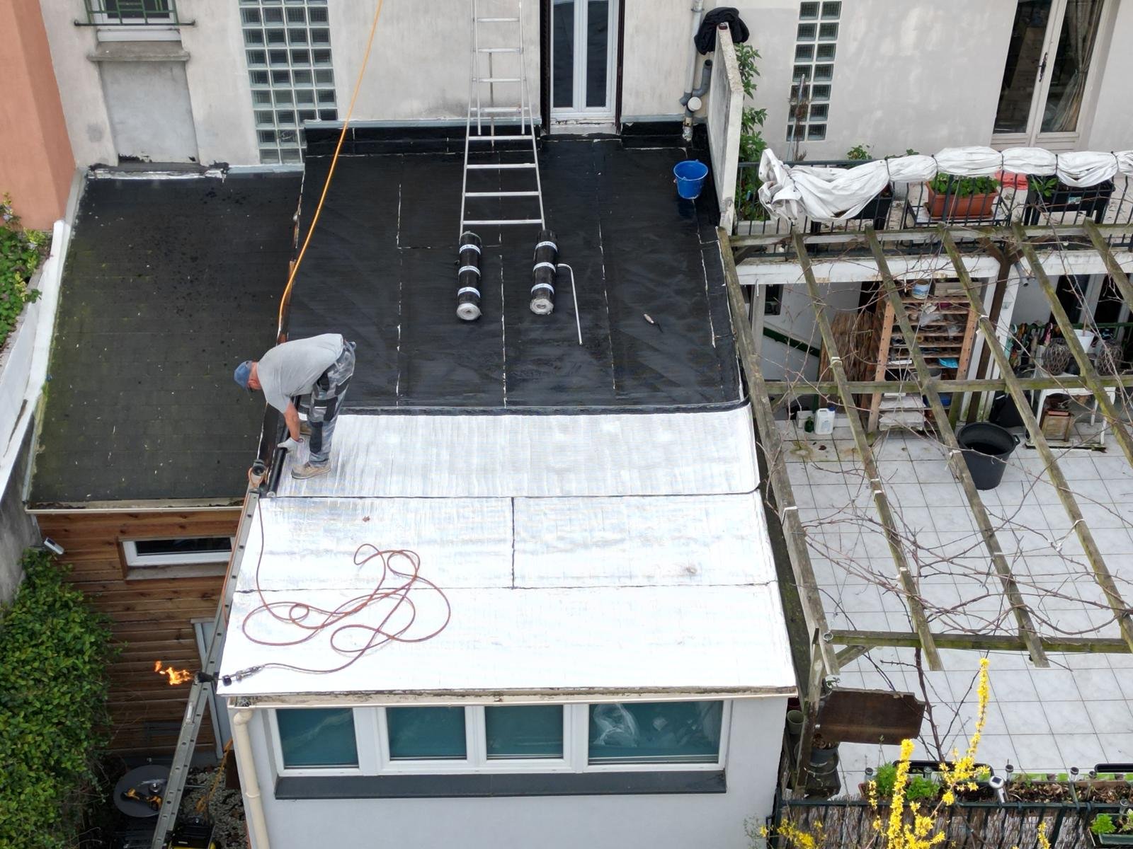 Pose d'une membrane bitumineuse à finition aluminium sur un toit-terrasse